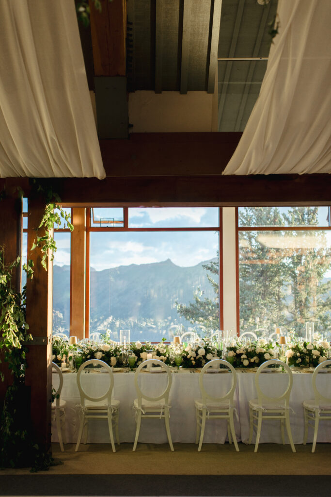 The Sundeck at Aspen Mountain is adorned with white and green tables and white tablecloths for a wedding.