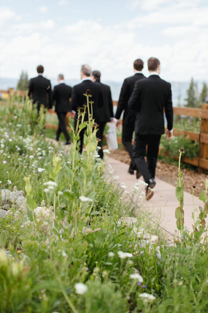 Blurry wedding guests walk through Aspen Mountain gardens