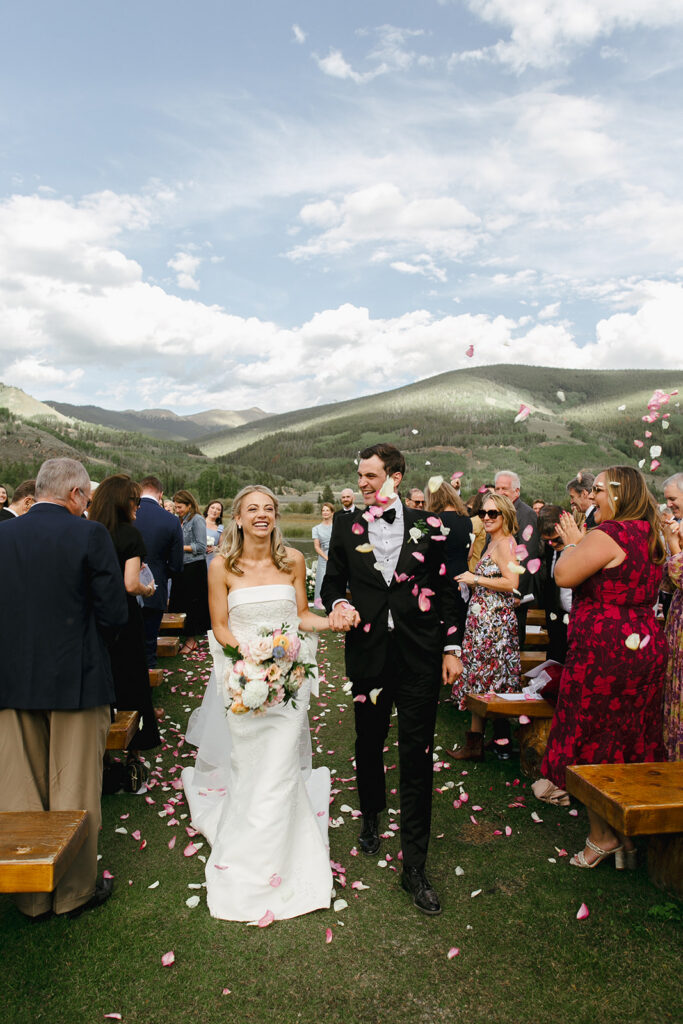 Petals fall on a newly married couple as they recess down the aisle at Camp Hale in Eagle County, Colorado.