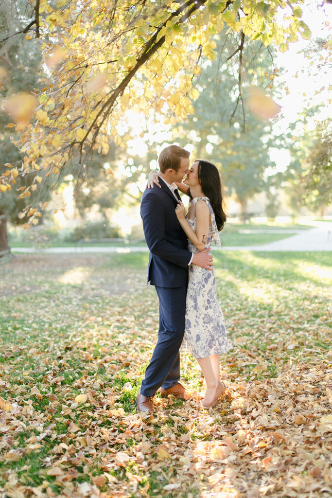 Couple kisses at Cheesman Park in the fall foliage