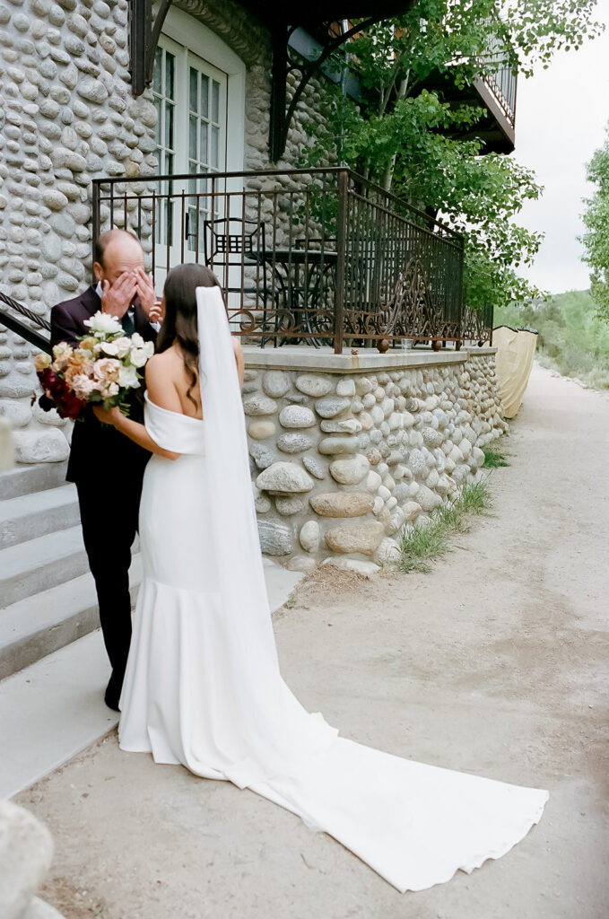 35mm film photo of groom wiping tears during first look of bride at wedding at the Surf Hotel in Buena Vista. Photo by Jordan Katz.