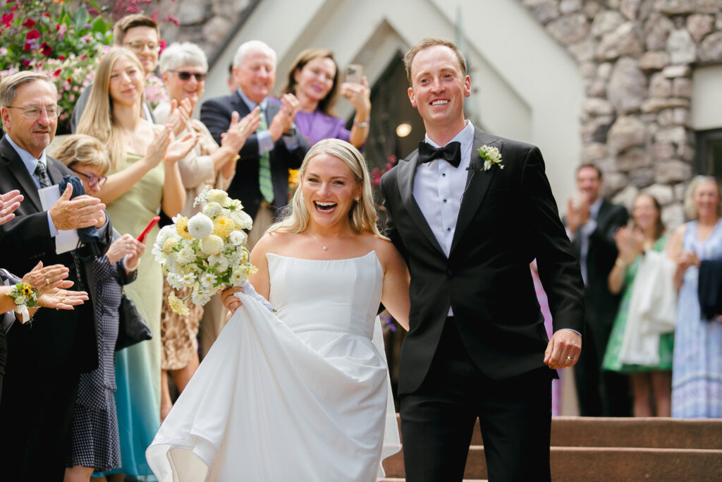 Couple recesses down the steps outside the Chapel at Beaver Creek