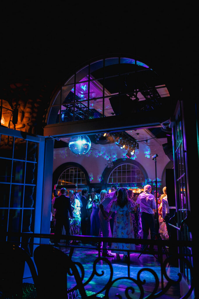 A dance floor is full of wedding guests under a glowing purple disco ball at the Surf Hotel in Buena Vista, Colorado. Shot by Jordan Katz.