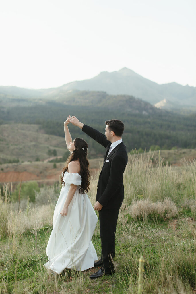 Newlyweds dance with Pikes Peak in the background at Pikes Peak Ranch in Woodland Park, Colorado.